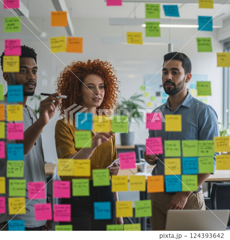 Young employees sticking notes on a glass wall in Young employees sticking notes on a glass wall in 124393642
