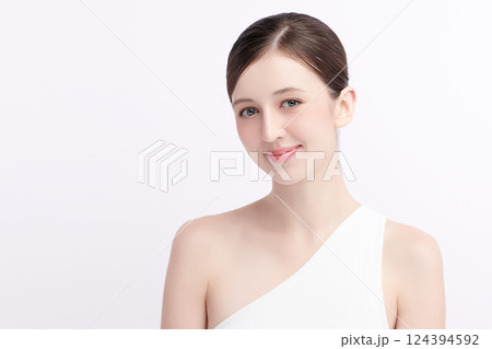 A beautiful young woman with clean, fresh skin against a white background. Skincare, facial treatment, cosmetology, beauty, and spa. An elegant portrait of an woman. 124394592