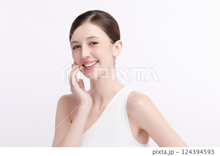 A beautiful young woman with clean, fresh skin against a white background. Skincare, facial treatment, cosmetology, beauty, and spa. An elegant portrait of an woman. 124394593