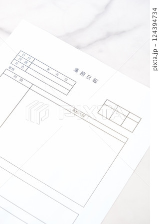 毎日の業務を終えた後、所要時間や作業内容、進捗状況を報告する書類、「業務日報」を記入する 124394734