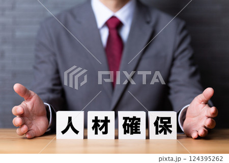 人材確保のブロックとスーツを着たミドル男性ビジネスマン 人材確保のブロックとスーツを着たミドル男性ビジネスマン 124395262
