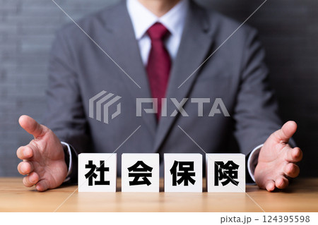 社会保険のブロックとスーツを着たミドル男性ビジネスマン 社会保険のブロックとスーツを着たミドル男性ビジネスマン 124395598