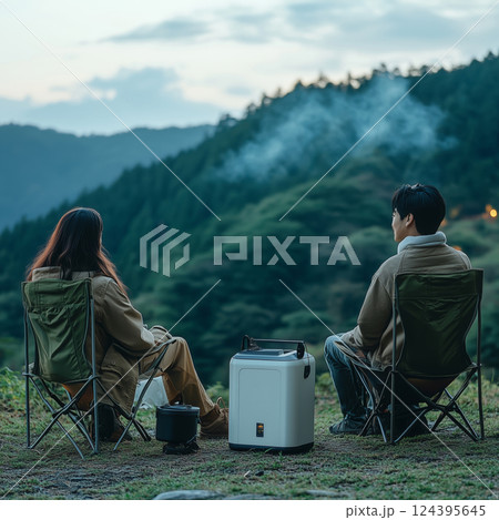 Relaxing evening in nature with friends by the camping chairs and mountains 124395645
