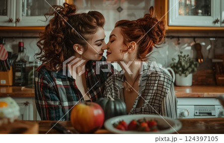 happy lesbian couple kissing and hugging at cozy kitchen, gay women kiss and embrace at home 124397105