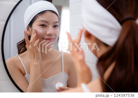 Beautiful young asian woman applying cream or lotion for rejuvenation skin on face. Beautiful young asian woman applying cream or lotion for rejuvenation skin on face. 124397536