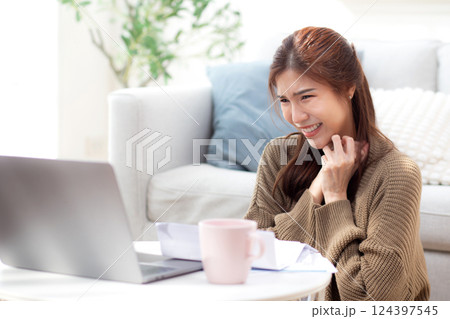 Young asian woman using laptop with happy and satisfaction in living room at home. 124397545