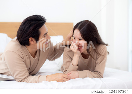 Young asian couple lying on bed relaxation with love and bonding together in bedroom at home. 124397564