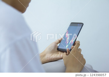 woman pointing, look directions change Average line Share price movement Stock trade up and down economy on smartphone work in the bedroom 124398057