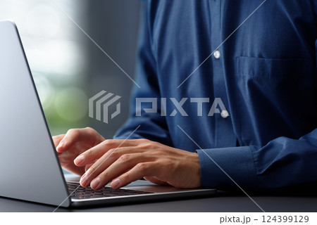 ノートパソコンのキーボードをタイピングする手のアップ。オフィスのデスクで働くビジネスマン。仕事でテク 124399129