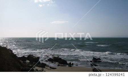 白波が打ち寄せる砂浜と日本海に浮かぶ佐渡島 白波が打ち寄せる砂浜と日本海に浮かぶ佐渡島 124399241