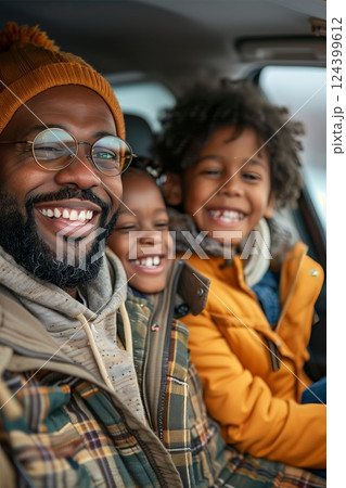 A joyful father and his two children smiling in the car, showcasing happiness and connection during a family outing. A joyful father and his two children smiling in the car, showcasing happiness and connection during a family outing. 124399612