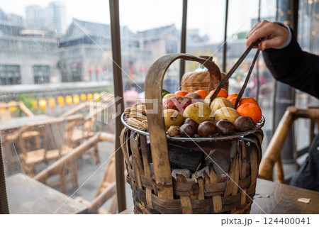 A Beautiful Colorful Fruit Basket Displayed on a Cozy Cafe Table for Guests to Enjoy A Beautiful Colorful Fruit Basket Displayed on a Cozy Cafe Table for Guests to Enjoy 124400041