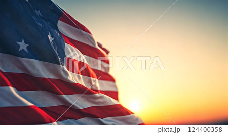 American flag waving in the breeze with sunset out of focus. 124400358
