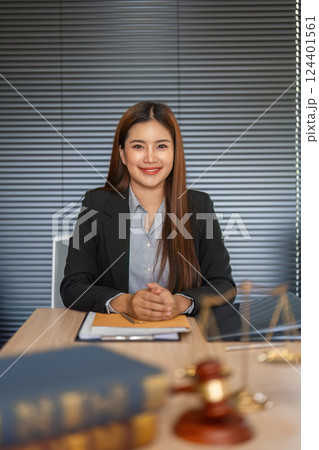 Professional Portrait of a Lawyer. A smiling attorney seated at her desk, ready to assist clients with legal matters. 124401561