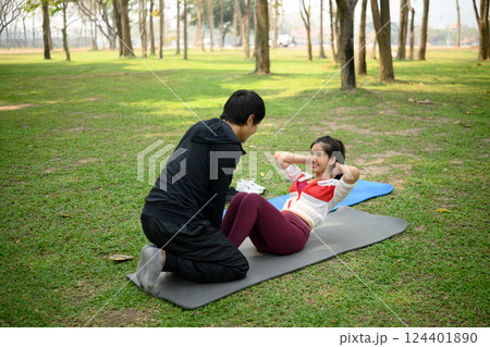 Happy young couple exercising together in a green park 124401890