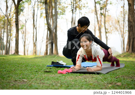 Man helping his partner during fitness exercise in a park. Healthy lifestyle concept 124401966