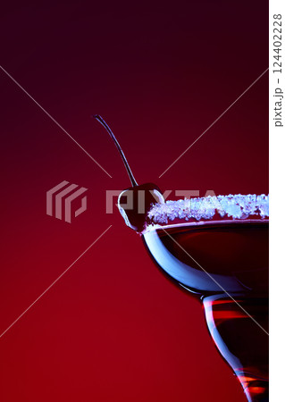 Bloody Mary. Closeup of cherry cocktail with sugar rim lit by neon red light against gradient background. Concept of night party Bloody Mary. Closeup of cherry cocktail with sugar rim lit by neon red light against gradient background. Concept of night party 124402228