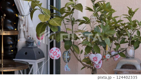 Colorful Easter egg decorations adorn a lively Easter tree in a cozy outdoor setting, celebrating the joy of Easter with vibrant pysanka designs Colorful Easter egg decorations adorn a lively Easter tree in a cozy outdoor setting, celebrating the joy of Easter with vibrant pysanka designs 124402335