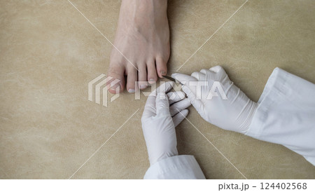 A podiatrist takes a scraping from a nail to examine for a fungal infection. Microbiological examination, taking a swab for the treatment of nail disease A podiatrist takes a scraping from a nail to examine for a fungal infection. Microbiological examination, taking a swab for the treatment of nail disease 124402568