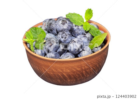Blueberries in a ceramic bowl isolated on white background. Dark blue, ripe, raw berries with mint leaves 124403902