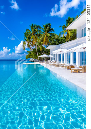 A large swimming pool with lounge chairs and umbrellas next to the ocean A large swimming pool with lounge chairs and umbrellas next to the ocean 124405353