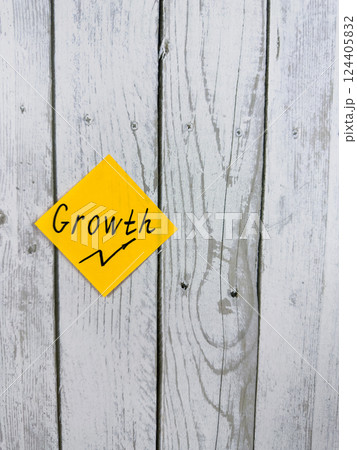 Vibrant sticky note with the word Growth positioned against a textured wooden background, representing the themes of personal development and advancing toward goals Vibrant sticky note with the word Growth positioned against a textured wooden background, representing the themes of personal development and advancing toward goals 124405832