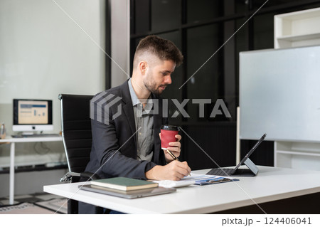 Businessman male working at office with laptop and documents on desk, financial adviser analyzing data. Businessman male working at office with laptop and documents on desk, financial adviser analyzing data. 124406041