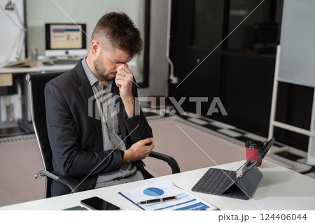 Young stressed caucasian businessman working in the office. Young stressed caucasian businessman working in the office. 124406044