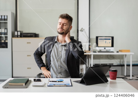 Male businessman is doing a stretchy posture due to sitting in the office for too long, office syndrome concept. Male businessman is doing a stretchy posture due to sitting in the office for too long, office syndrome concept. 124406046