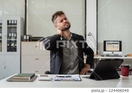 Male businessman is doing a stretchy posture due to sitting in the office for too long, office syndrome concept. Male businessman is doing a stretchy posture due to sitting in the office for too long, office syndrome concept. 124406049