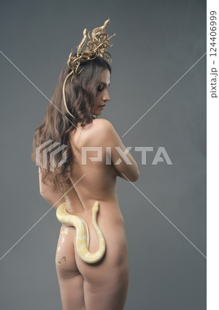 Woman poses elegantly with a snake, showcasing beauty and artistry 124406999