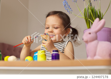 Little child girl paint Easter eggs at home. kid is preparing for Easter. Little child girl paint Easter eggs at home. kid is preparing for Easter. 124407178