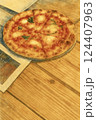 香ばしく焼き上がったマルゲリータピザと木のテーブル、温もりあるランチシーンを描いたイラスト 124407963