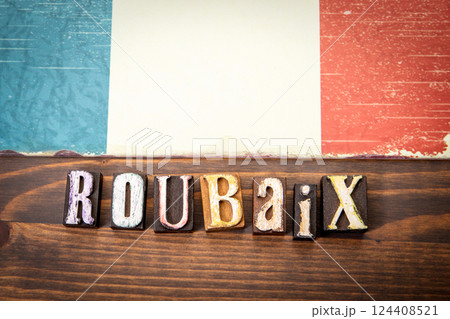 ROUBAIX. Flag and alphabet letters on wooden texture background 124408521