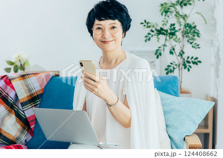 リビングでパソコンを使うミドル女性 リビングでパソコンを使うミドル女性 124408662