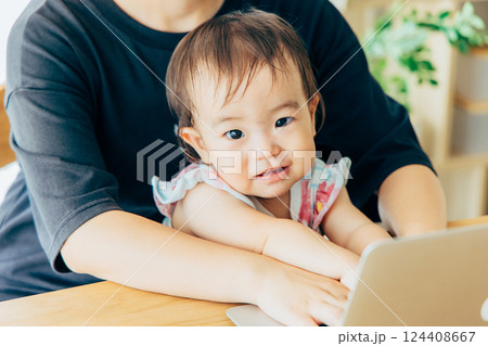 リビングでパソコンを見る親子 124408667