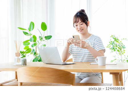 リビングでスマホを使う若い女性 124408684