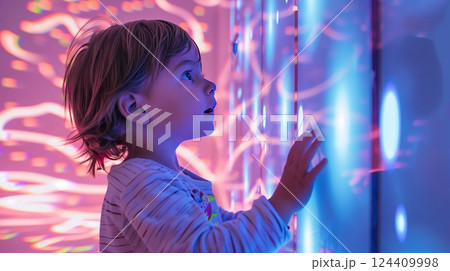 A child in a sensory room with calming light patterns and soothing sounds enjoys a relaxing environment. 124409998