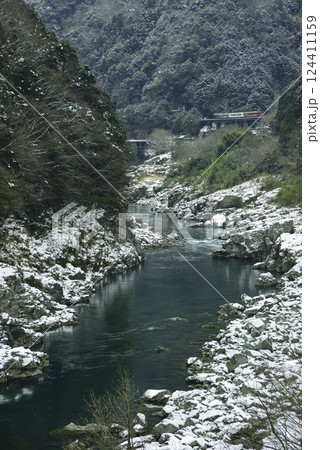 雪景色の小歩危峡沿いを徐行する観光列車 124411159
