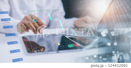 Investors using laptop to analyze stock market, Investment strategies, Business growth analysis, Companies with long term competitive advantage, With city backdrop. 124412091