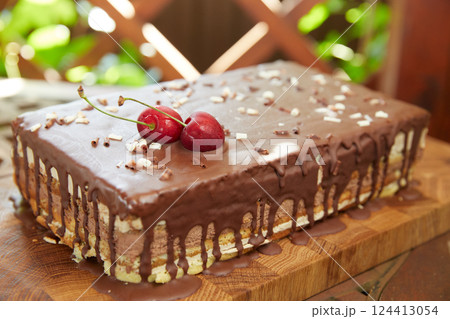 Delicious chocolate cake decorated with cherries. Delicious chocolate cake decorated with cherries. 124413054