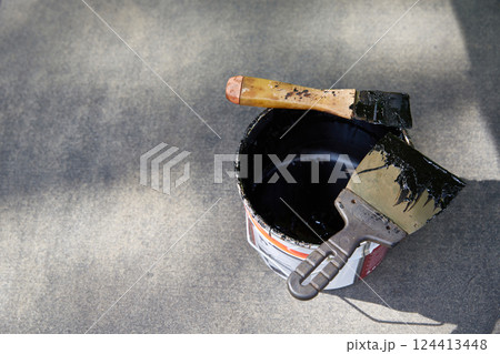 Mastic for the roof. Spatulas in waterproofing mastic. Copy space Mastic for the roof. Spatulas in waterproofing mastic. Copy space 124413448