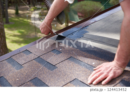 Worker's hands are smeared with waterproofing mastic for the roof. Worker's hands are smeared with waterproofing mastic for the roof. 124413452