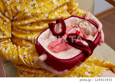 A doll made of polymer clay in children's hands. Hobby. Miniature and doll houses 124413455