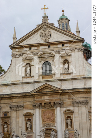 Baroque Facade of a Historic Church with Sculptures and Cross 124413777