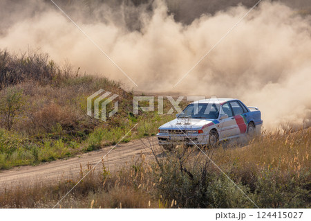 Large Cloud of Dust and Rally Car on a Dirt Corner Large Cloud of Dust and Rally Car on a Dirt Corner 124415027