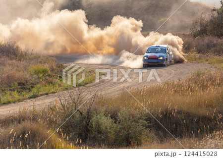 Rally Car on a Turn and a Cloud of Dust in the Sunlight Rally Car on a Turn and a Cloud of Dust in the Sunlight 124415028