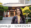 お寺の前でにこやかに写真に収まる女性 124415254