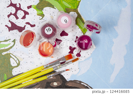 Painting by numbers. Set to paint the picture, includes a canvas, paints of different colors, brushes. Top view. Painting by numbers. Set to paint the picture, includes a canvas, paints of different colors, brushes. Top view. 124416085