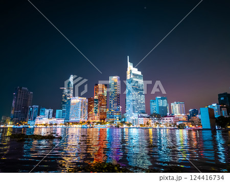 night view of illuminated Ho Chi Minh city skyline and Saigon river, neon street lights of financial downtown district with tall skyscraper towers, Vietnam aerial drone view 124416734